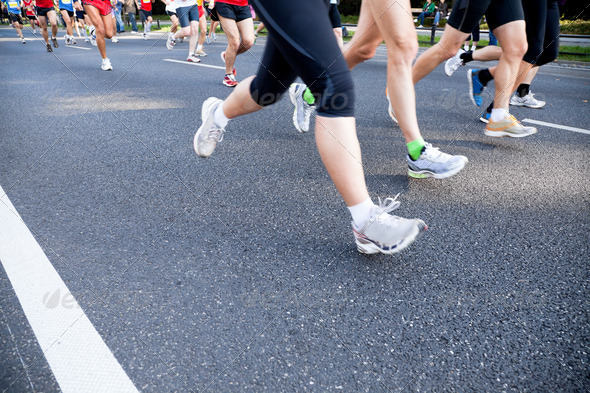 People running in city marathon on street