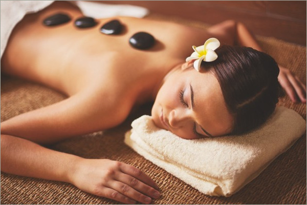 woman laying on bed and enjoying stone massage